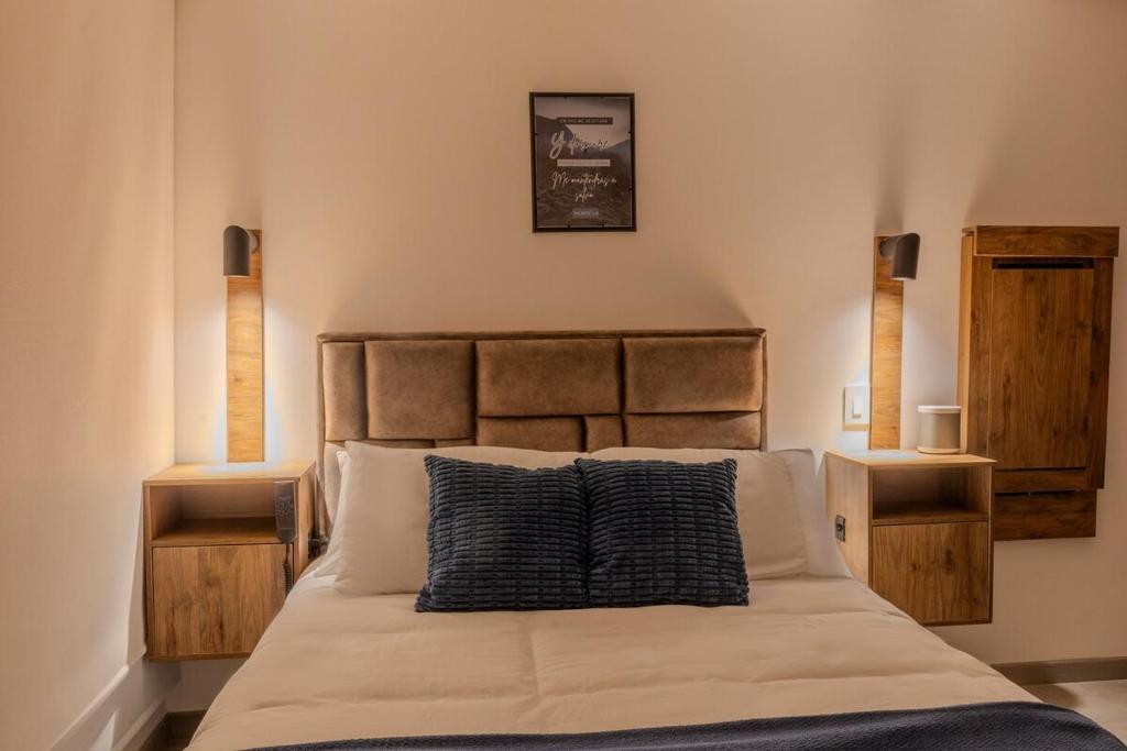 ein Schlafzimmer mit einem Bett mit einem schwarzen Kissen darauf in der Unterkunft Apartasuite Smart cerca de la Fundación Santa Fé in Bogotá