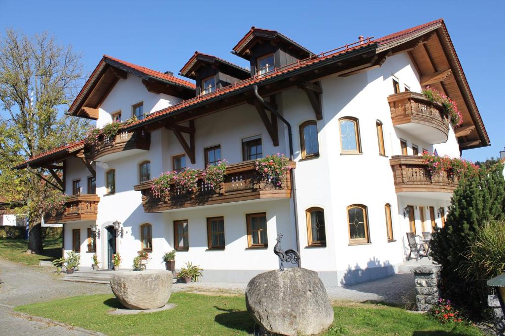 un gran edificio blanco con balcones y flores. en Landgasthof Schmalhofer en Tittling