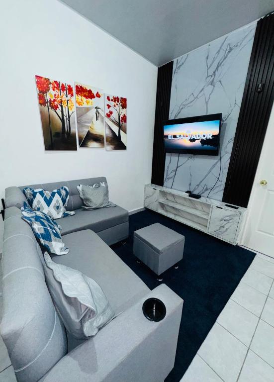 a living room with a couch and a flat screen tv at Casa Monaco in San Miguel