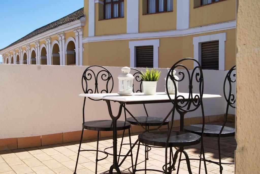 una mesa y sillas sentadas en un balcón en Apartamentos Turísticos La Encarnación, en Sevilla