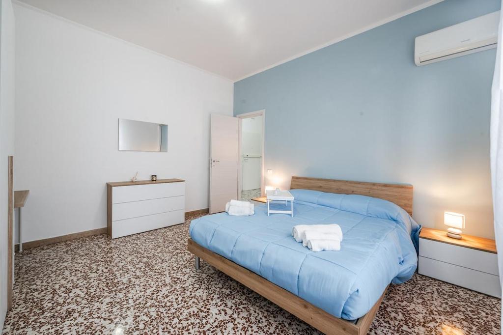 ein Schlafzimmer mit einem blauen Bett mit Handtüchern darauf in der Unterkunft Smart Stay near Policlinico & City Center in Modena