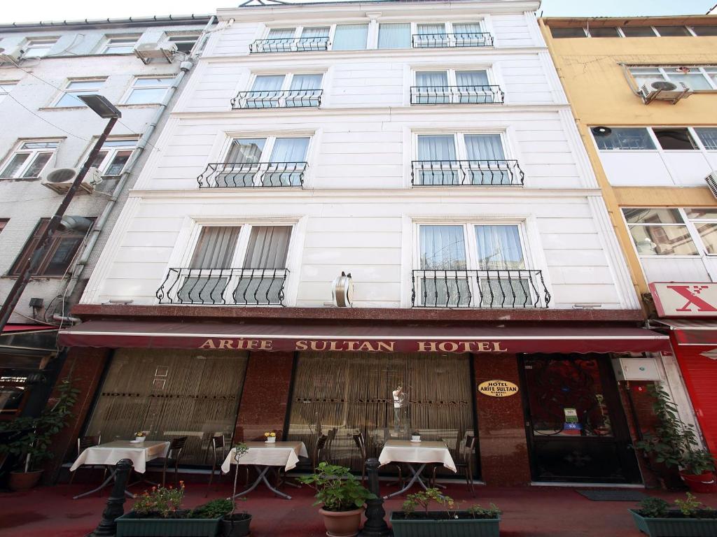 a white building with tables in front of it at Arife Sultan Hotel in Istanbul