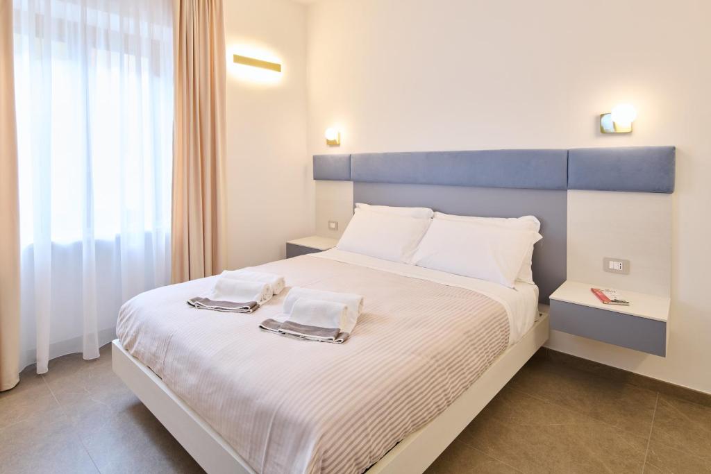 a bedroom with a large bed with a blue headboard at San Nicola Rooms Siracusa in Syracuse