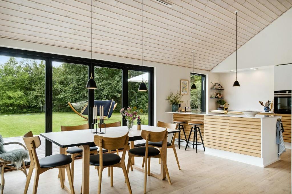 a kitchen and dining room with a table and chairs at Modern Sleek House In Gedser in Gedser