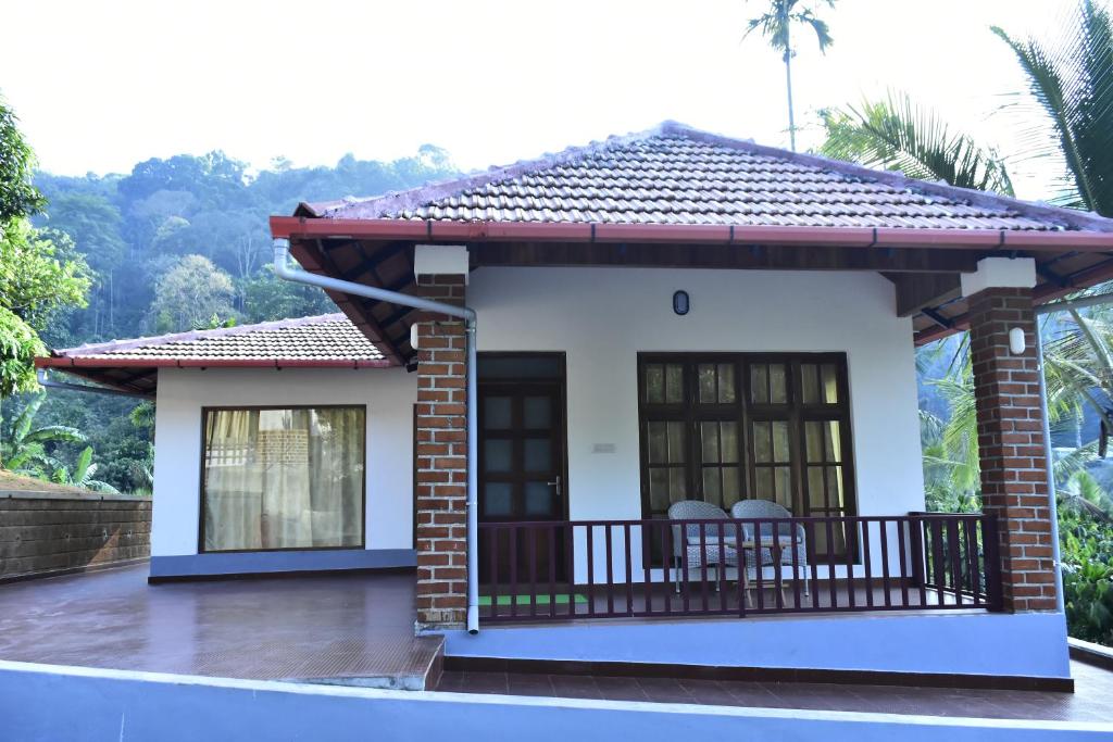 a small house with a balcony at River Valley Retreat Coorg in Madikeri