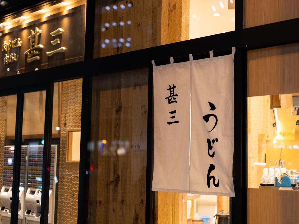 a sign hanging on a window of a restaurant at APA Hotel Shibuya Dogenzakaue in Tokyo