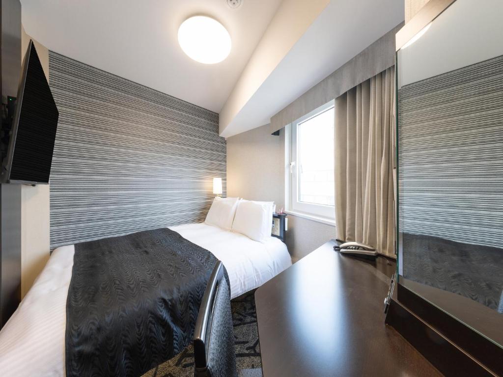 a hotel room with a bed and a large window at APA Hotel Shibuya Dogenzakaue in Tokyo