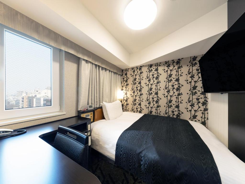 a hotel room with a bed and a window at APA Hotel Shibuya Dogenzakaue in Tokyo