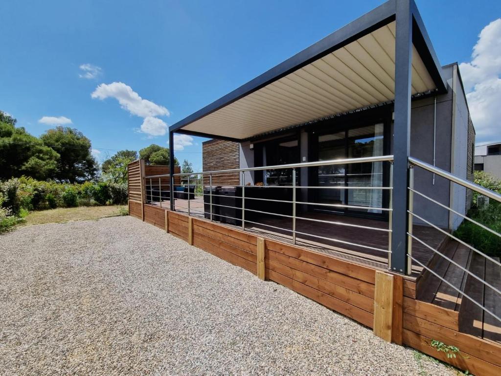 une maison moderne entourée d'une clôture en bois dans l'établissement Cottage du Lac 63, à Olonzac