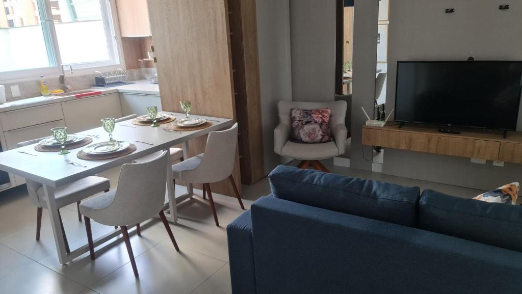 a living room with a table and a blue couch at Apartamento Familiar! in Pelotas