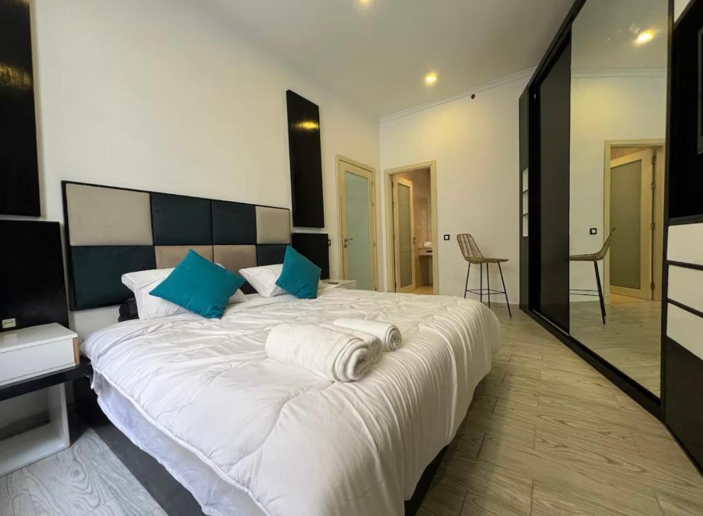 a bedroom with a large white bed with blue pillows at Tingis Concept in Tangier