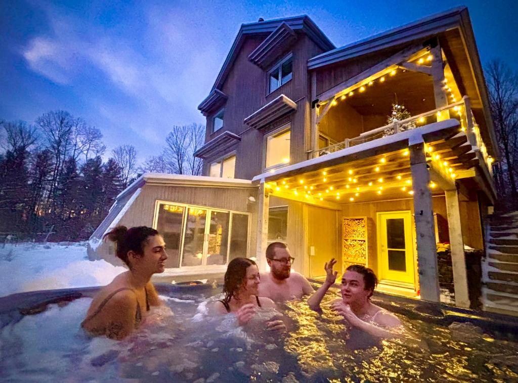 a group of people swimming in a jacuzzi at Le Camp Caché Shefford in Shefford