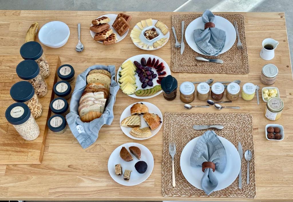 a wooden table with plates of food on it at Le Camp Caché Shefford in Shefford