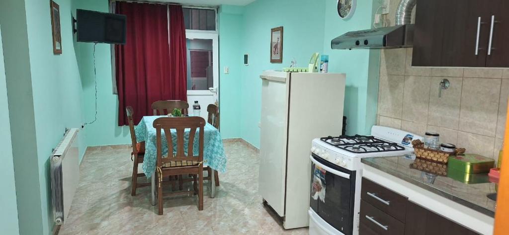 a kitchen with a table and a white refrigerator at Departamento Dulce Adelina I - Zona Céntrica in Río Grande