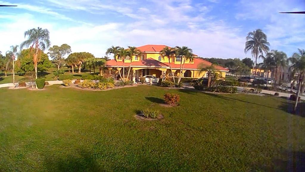 een huis met een grote tuin met een groen gazon bij Wellington Hideaway Villa in Wellington