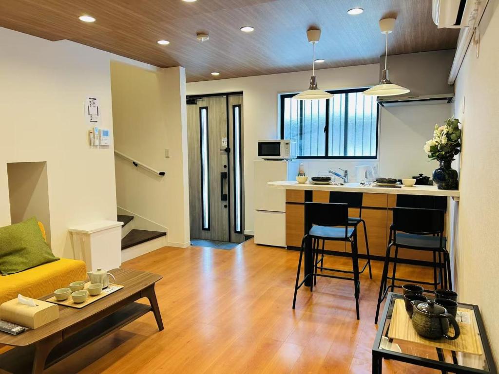 a living room with a couch and a table and a kitchen at ASOBO OSAKA Kuromon 2nd in Osaka