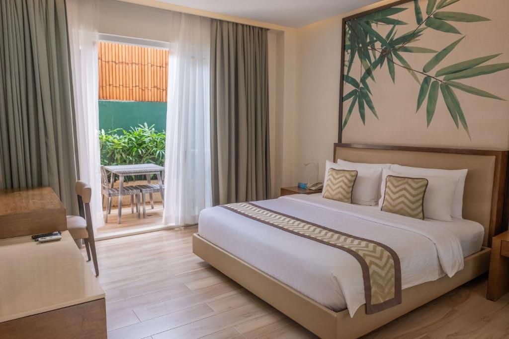 a hotel room with a bed and a balcony at Boracay Haven Suites in Boracay