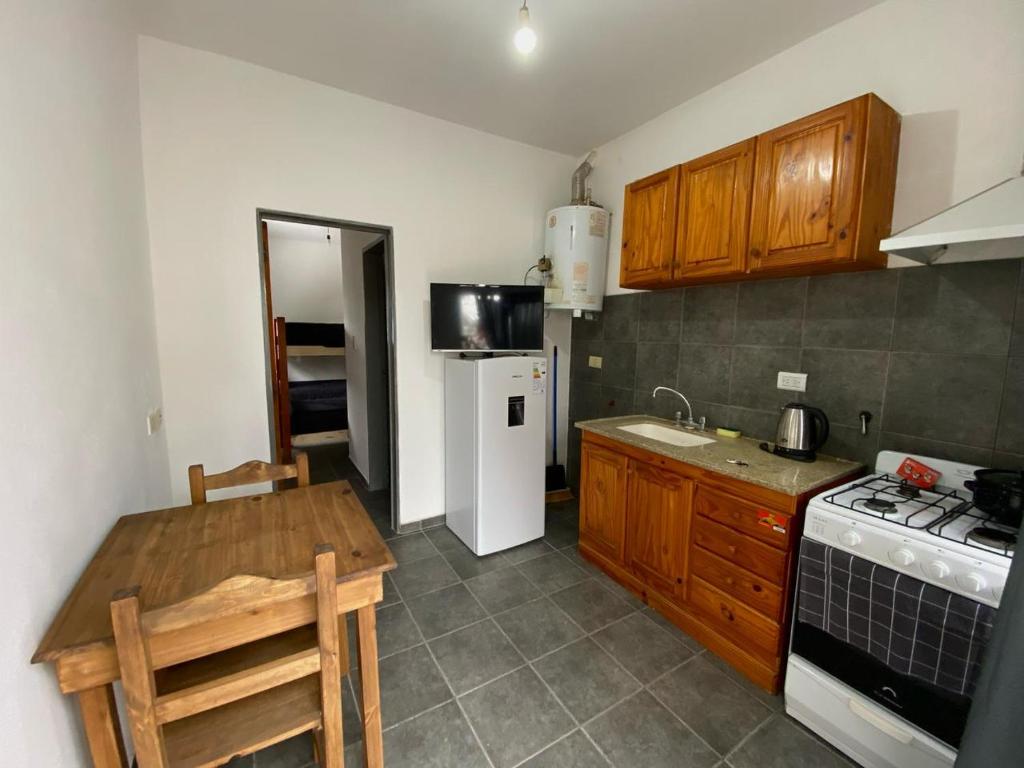 een keuken met een fornuis en een witte koelkast bij Departamento cómodo in Jesús María