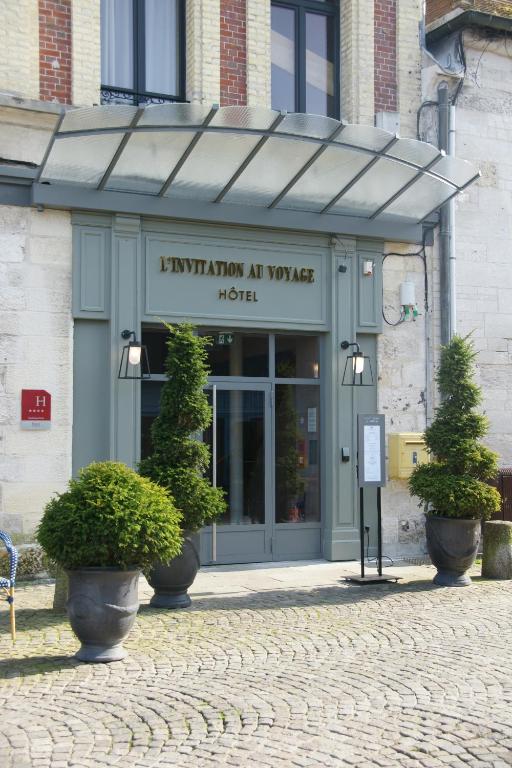 an entrance to a hotel with potted trees in front of it at L'INVITATION AU VOYAGE - Hôtel & Spa in Honfleur