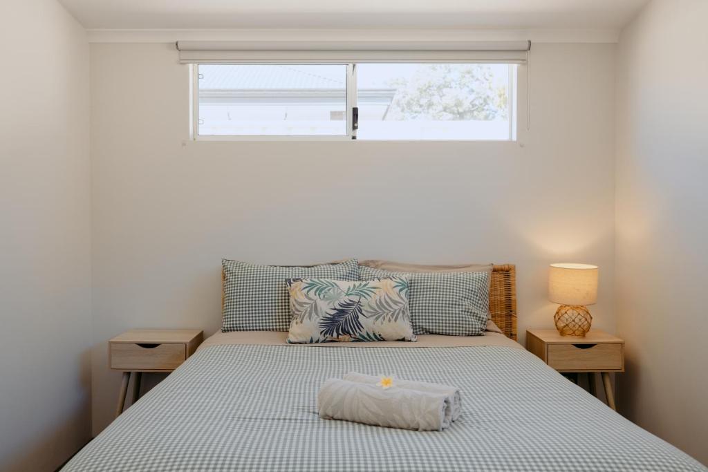 ダンズボローにあるPapillon Dunsborough Family & Pet Friendly Holiday Homeの枕が置かれたベッドのある寝室