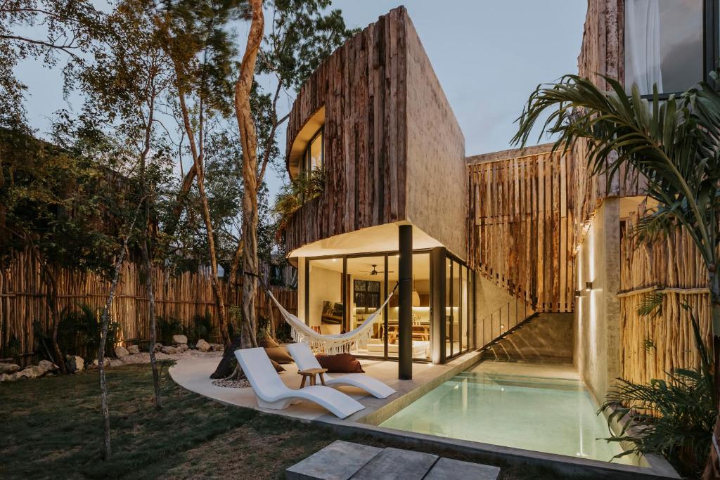 a house with a hammock and a swimming pool at Media Luna BoHo Chic Villa E11 Pvt Pool Concierge in Tulum