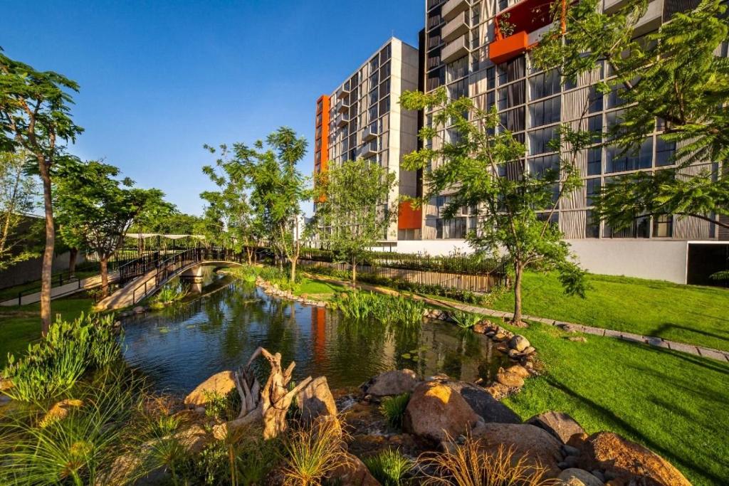 グアダラハラにあるHospedaje cerca Auditorio Telmex con A/Cの建物の前の川のレンダリング