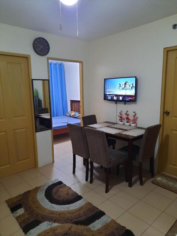 a dining room with a table and chairs and a tv at Wave Crest Retreat at Marina Spatial Dumaguete in Dumaguete