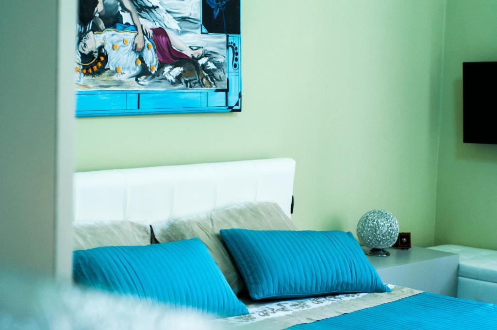 a bedroom with a bed with blue pillows at B&B Villa Roma in Piazza Armerina