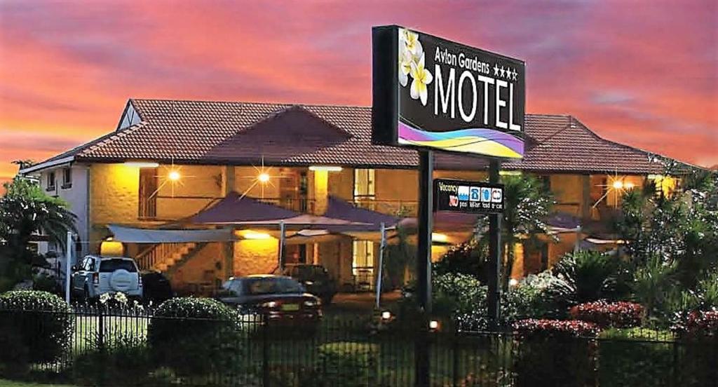 a motel sign in front of a house at Avlon Gardens Motel in Ballina