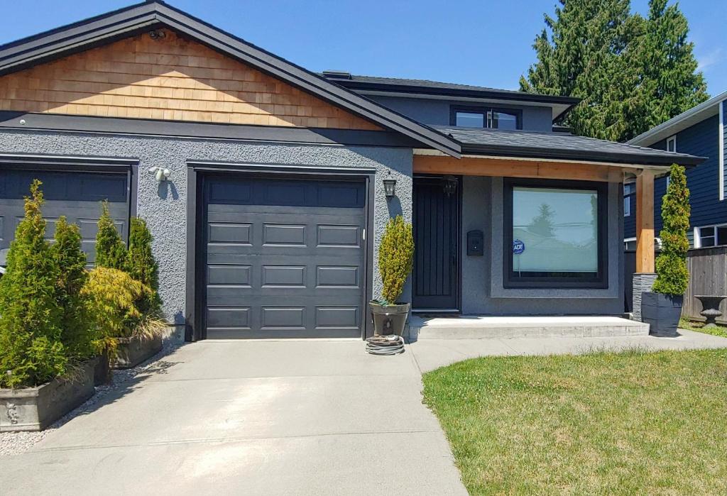 a house with a garage and a driveway at Burnaby 4 bed 3 bath duplex in Burnaby