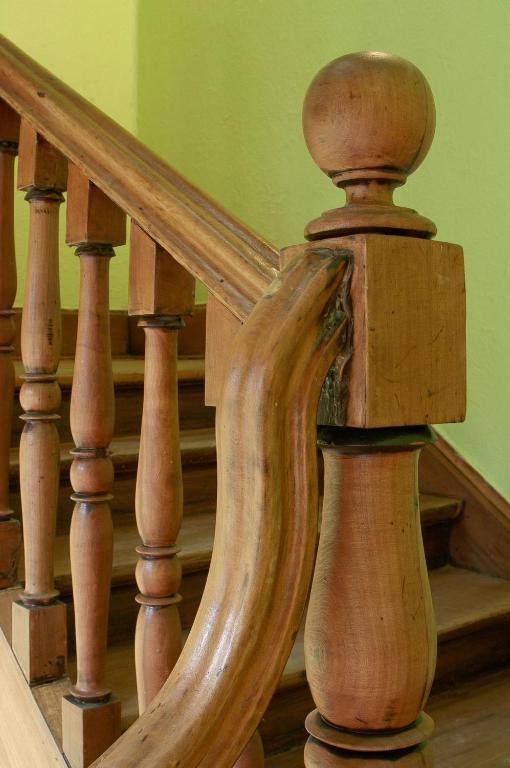 a wooden spiral staircase with wooden railings at Aji Hostel in Santiago