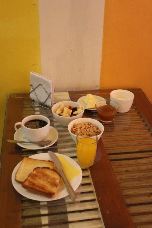 a table with breakfast foods and drinks on it at Aji Hostel in Santiago