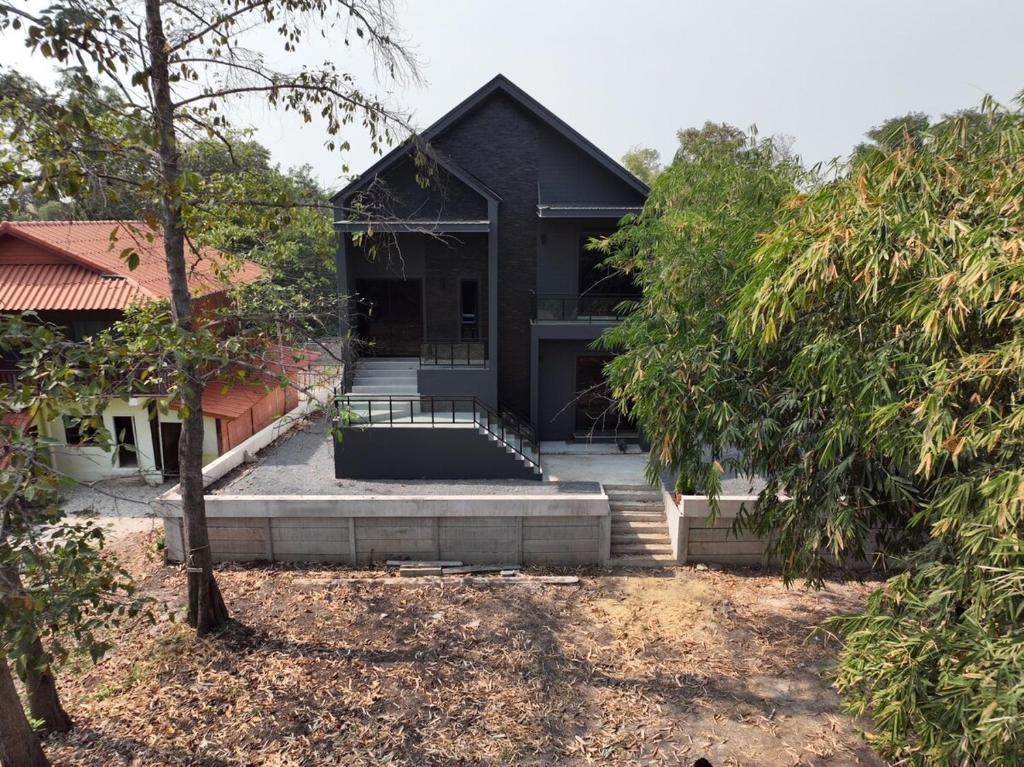 una casa negra con escaleras que conducen a ella en Top Ayutthaya Home of peace the sound of birds, en Ban Phlap