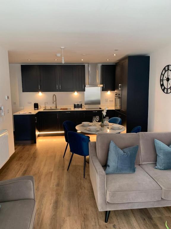 a living room with a couch and a table and a kitchen at The Sunrise Den-Lovely 2 bedroom apartmentParking in Harlow
