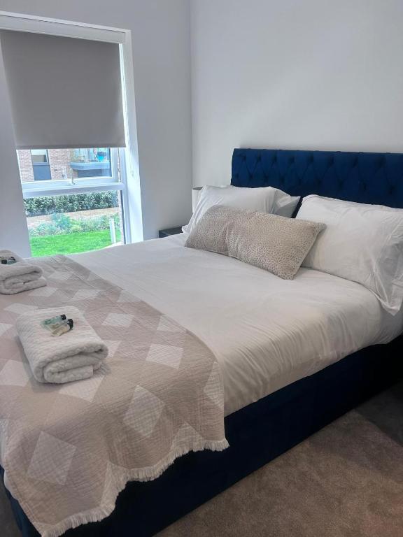 a bed with towels on it in a bedroom at The Ivy Abode 2 bedroom ApartmentParking in Harlow
