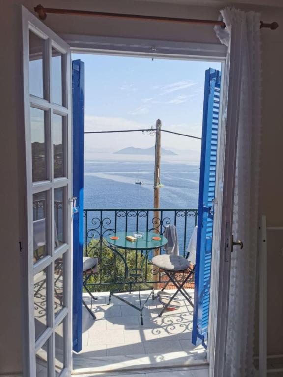 a door open to a balcony with a view of the ocean at Aprilis Apartments 2 in Kiónion