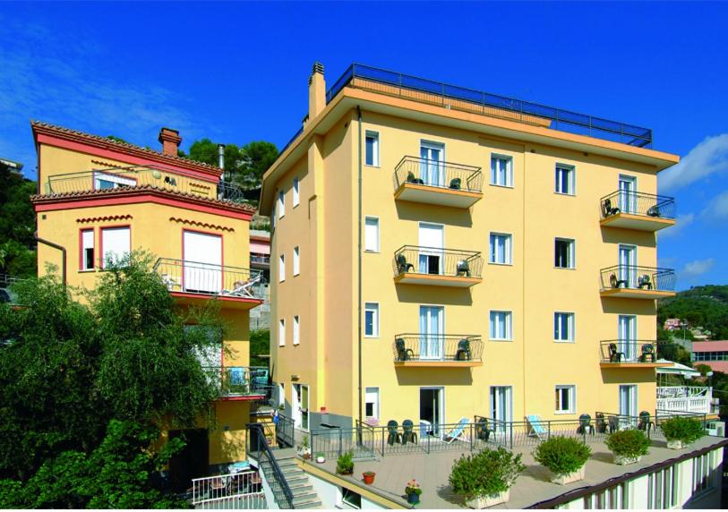 un bâtiment jaune avec des balcons sur son côté dans l'établissement Hotel Tritone, à Laigueglia