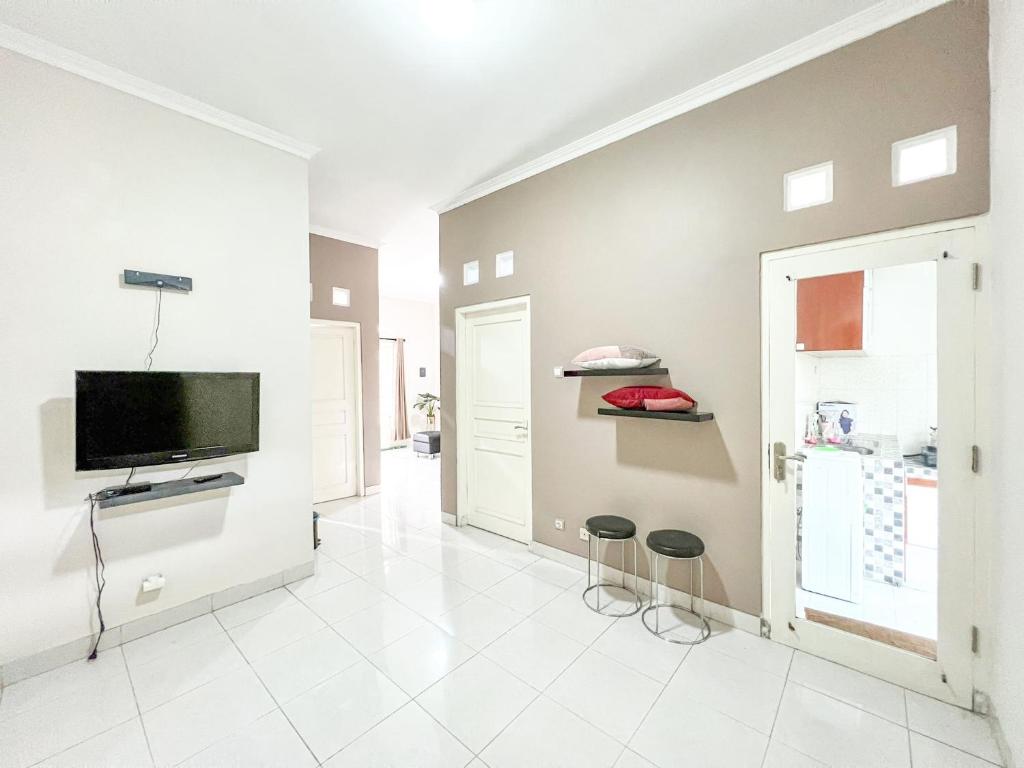 NgaglikGriya Lojajar Homestay Jogja的客厅墙上有一台平板电视