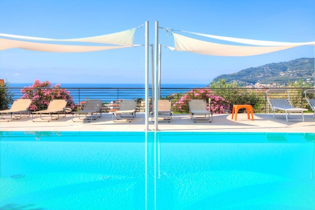 een zwembad met stoelen en uitzicht op de oceaan bij Appartamenti Villa il Poggiolo in Diano Marina
