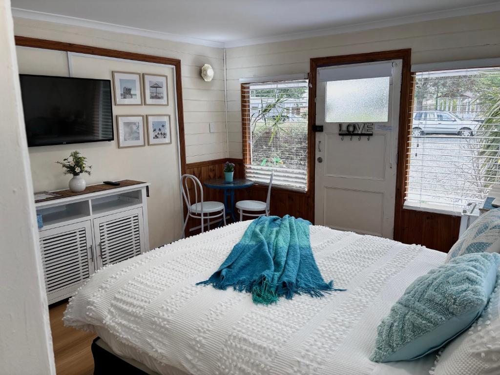 ein Schlafzimmer mit einem Bett, einem Fernseher und einem Tisch in der Unterkunft Stonez Boutique Accommodation in Clunes