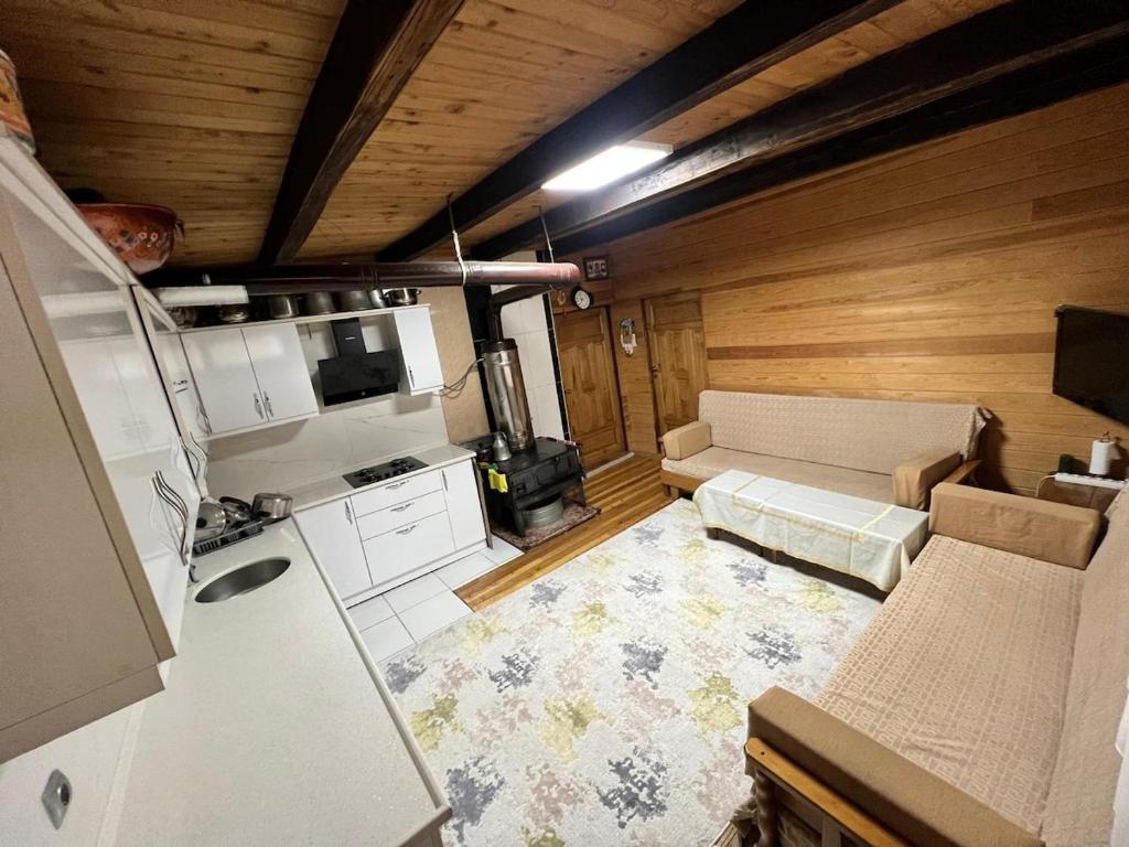 a kitchen with a couch and a stove in a room at Ahşap Tatil Evi in Çamlıhemşin