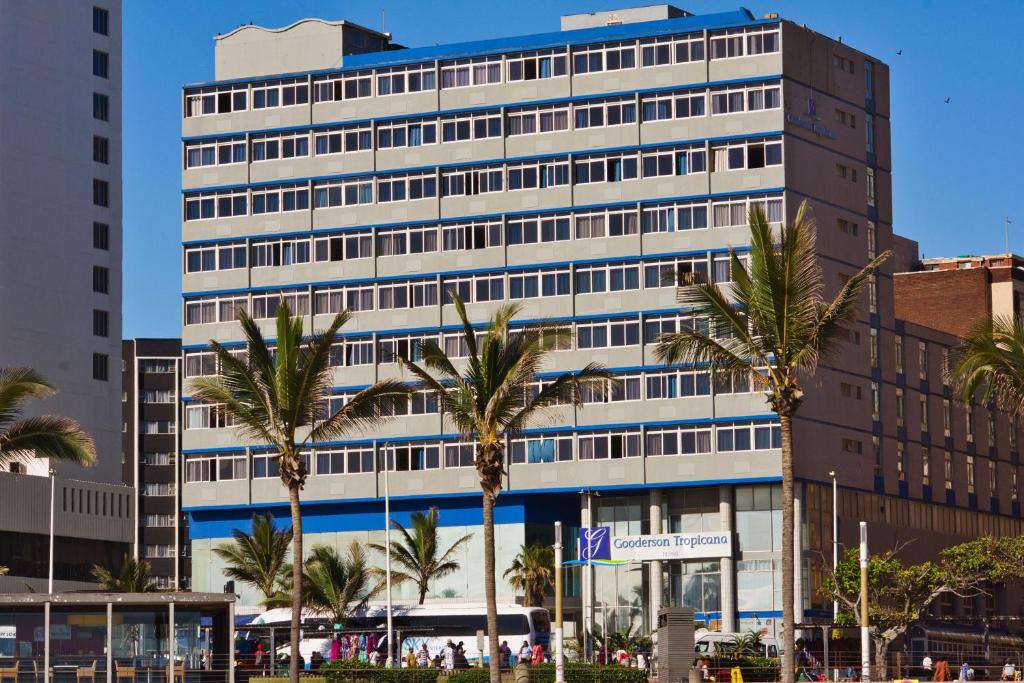 ダーバンにあるGooderson Tropicana Hotelのヤシの木が前に生えている高い建物
