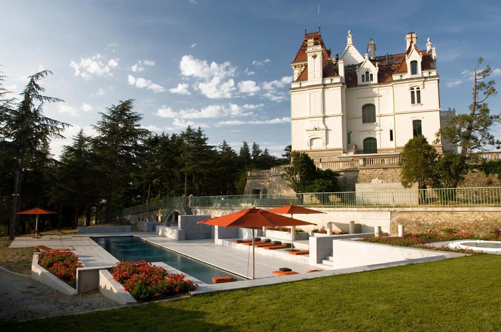 un bâtiment avec une piscine en face d'un bâtiment dans l'établissement B&B Château Valmy - Teritoria, à Argelès-sur-Mer