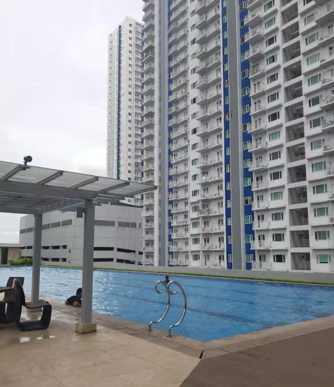 a swimming pool with tall buildings in the background at Theodore Alfonzo rental in Manila