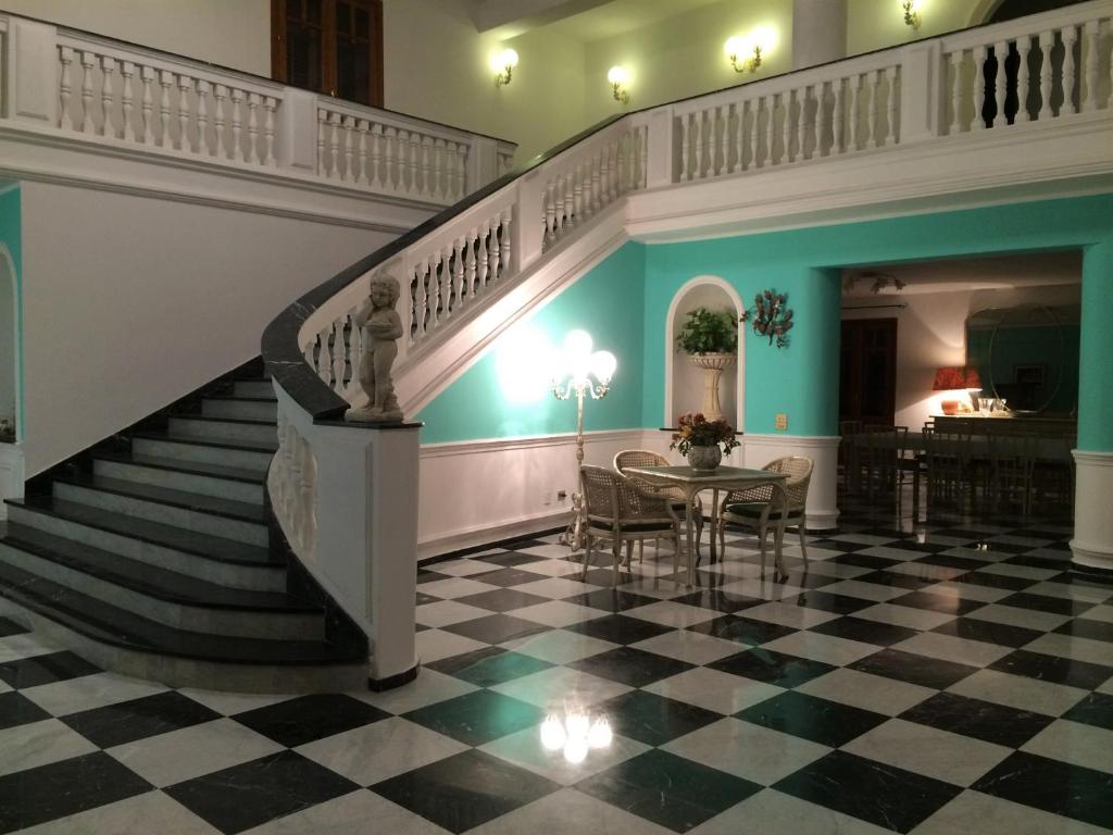 a hallway with a staircase and a table in a building at Palazzo Scavone in Palermo