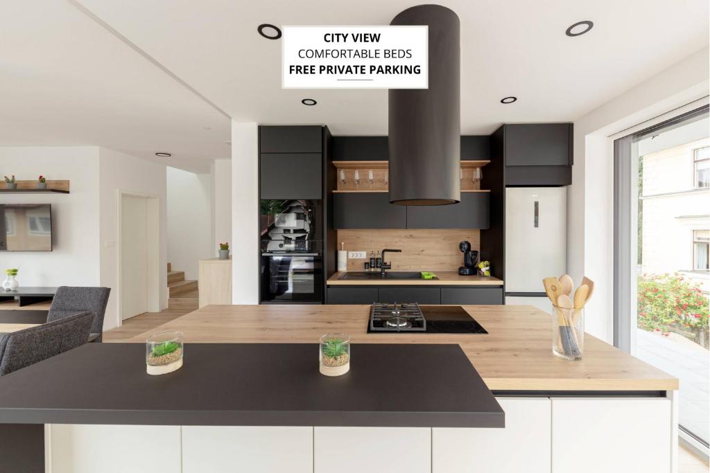 a kitchen with white cabinets and a black counter top at Apartment Božica in Ljubljana