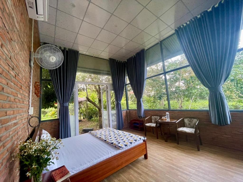 a bedroom with a bed with blue drapes at Tea Garden House in Xã Tân Phát