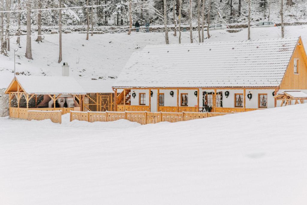 eine Hütte im Schnee mit schneebedecktem Boden in der Unterkunft LOLO Park Resort in Lacul Roşu