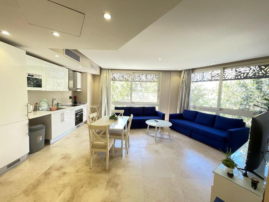 a living room with a blue couch and a table at Cozy 1BD in Mangroovy El Gouna in Hurghada