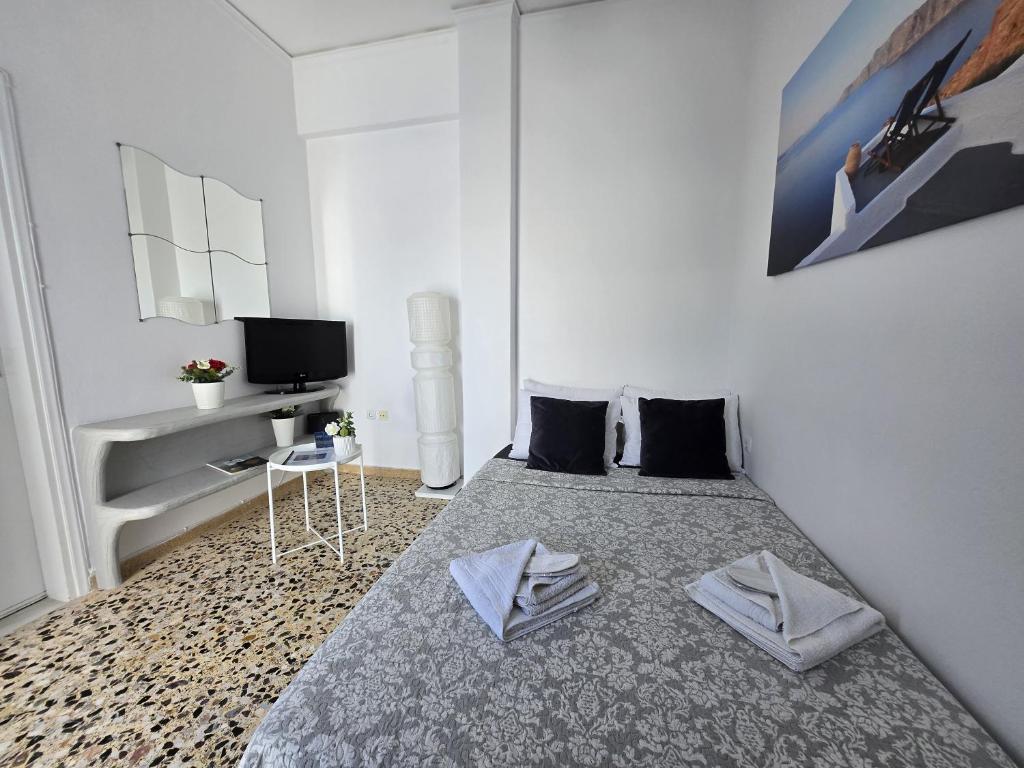 una camera da letto con un letto con due asciugamani sopra di Maraki's Little House Santorini a Kamari